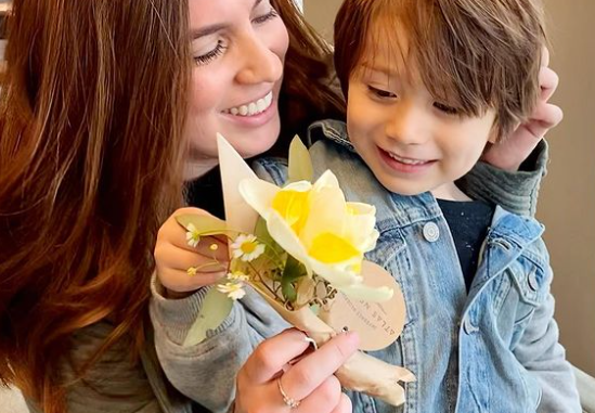 smiling women with child and a mini bouquet