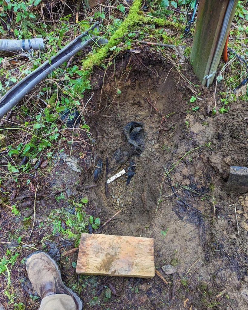 Digging around a broken water pipe with dirt and water showing.