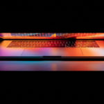 Colorful lights coming from the screen and keyboard of a laptop against a dark background.