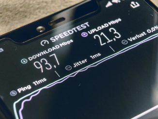 Mobile phone with internet speed test results on the screen.