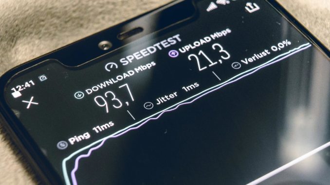 Mobile phone with internet speed test results on the screen.